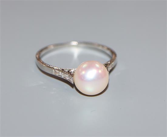 A pearl, diamond and white metal (stamped platinum) ring, the single pearl in fancy openwork setting with diamond-set shoulders.